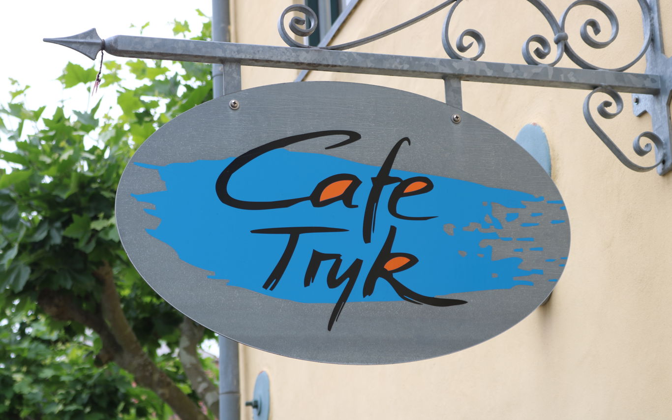 Skilt med navnetræk over Cafe Tryks indgang