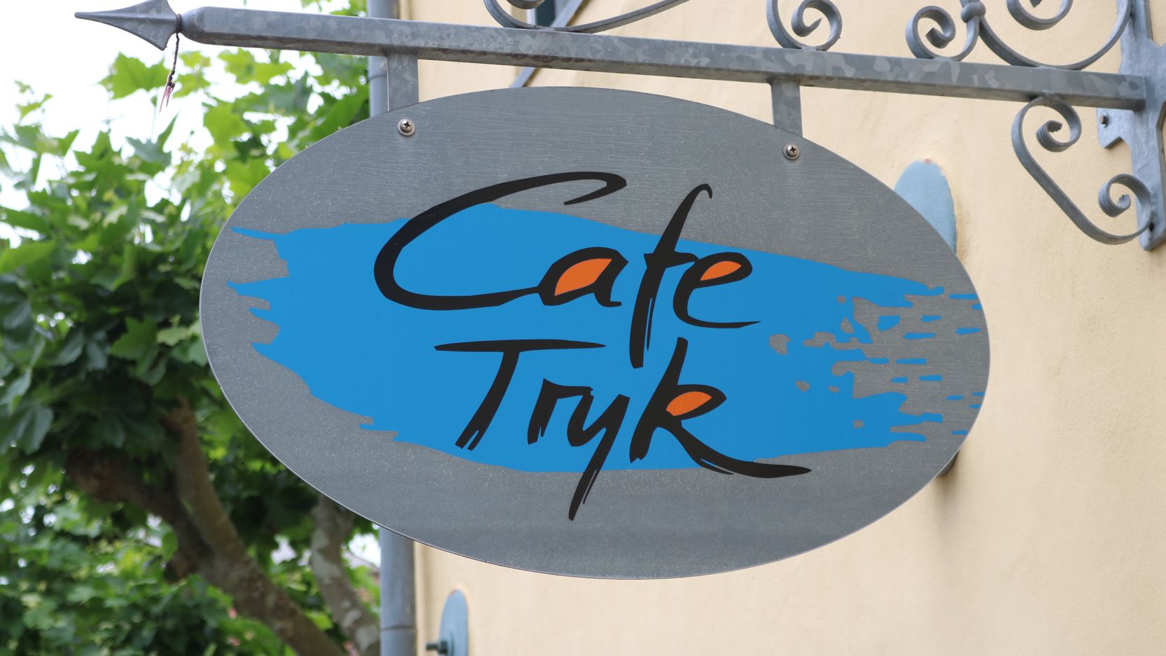 Skilt med navnetræk over Cafe Tryks indgang