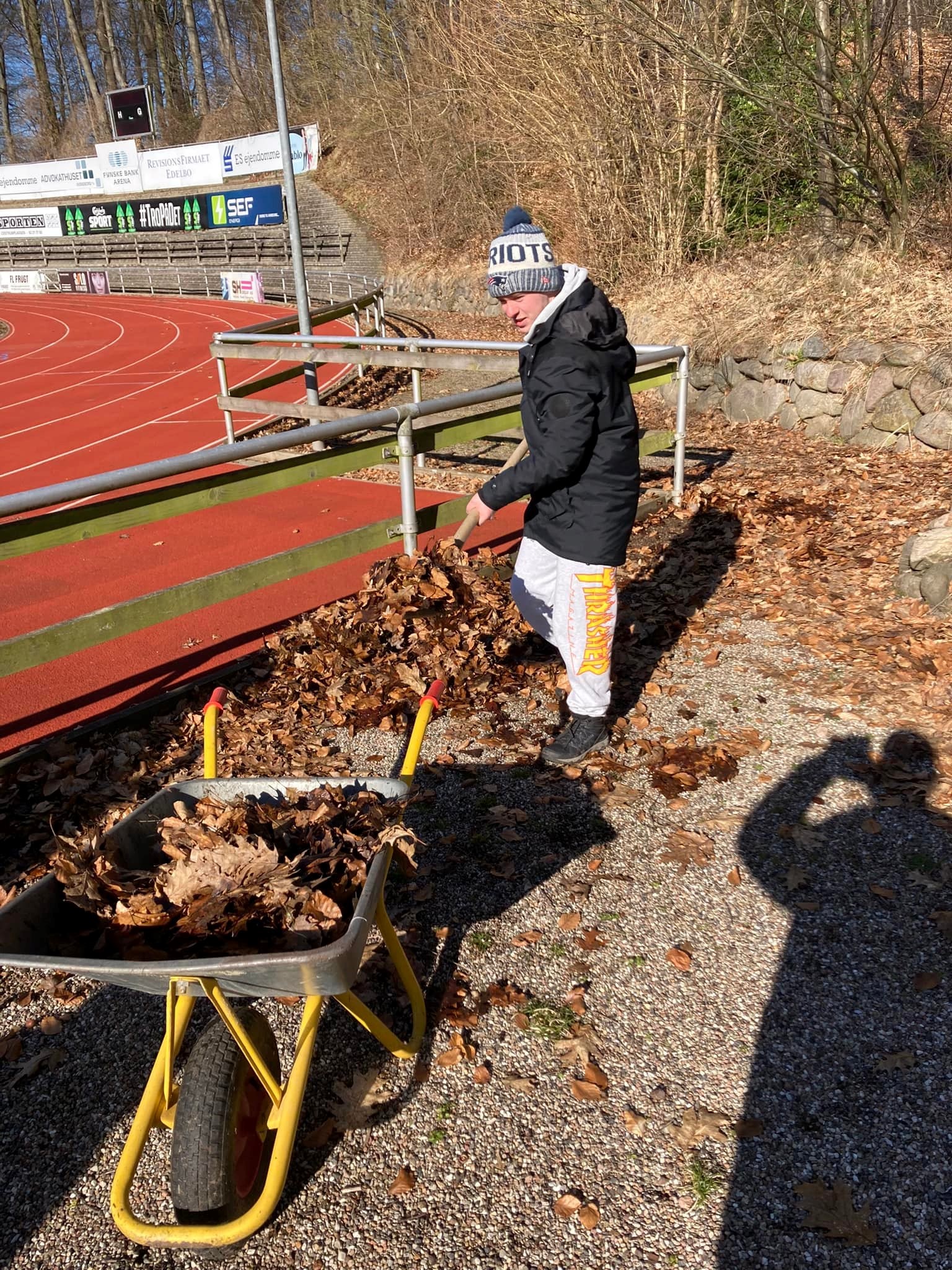 Foto af arbejde med at fjerne blade på Høje Bøge stadion